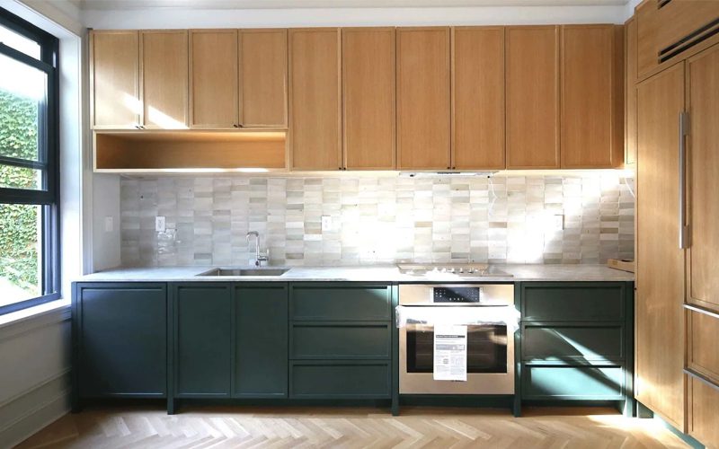 A kitchen with green cabinets and a stove.